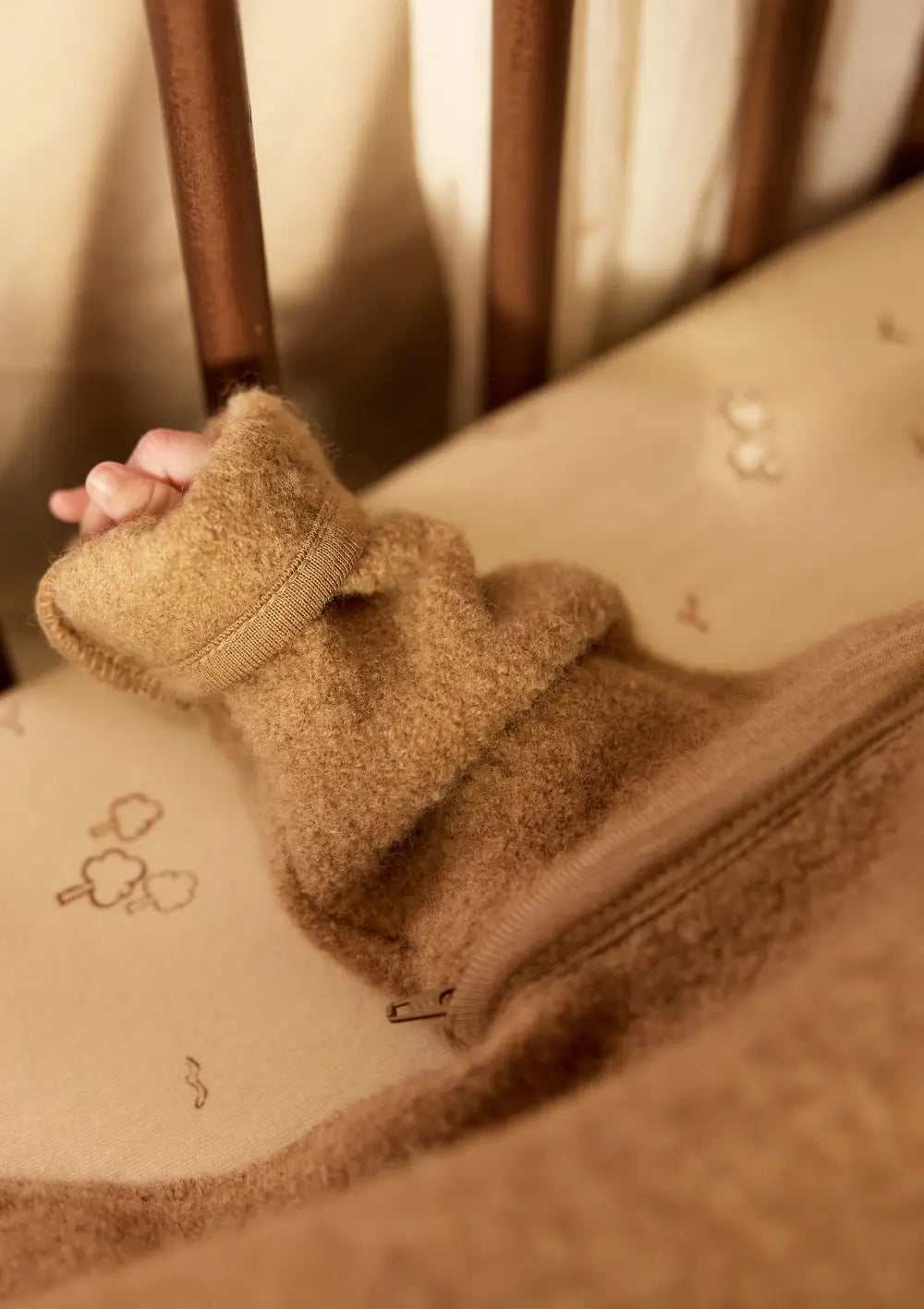 Nahaufnahme einer kleinen Babyhand; Baby trägt den Jollein Merino Baby Schlafsack mit abnehmbaren Ärmeln TOG 2,0-2,5 Dark Hazel