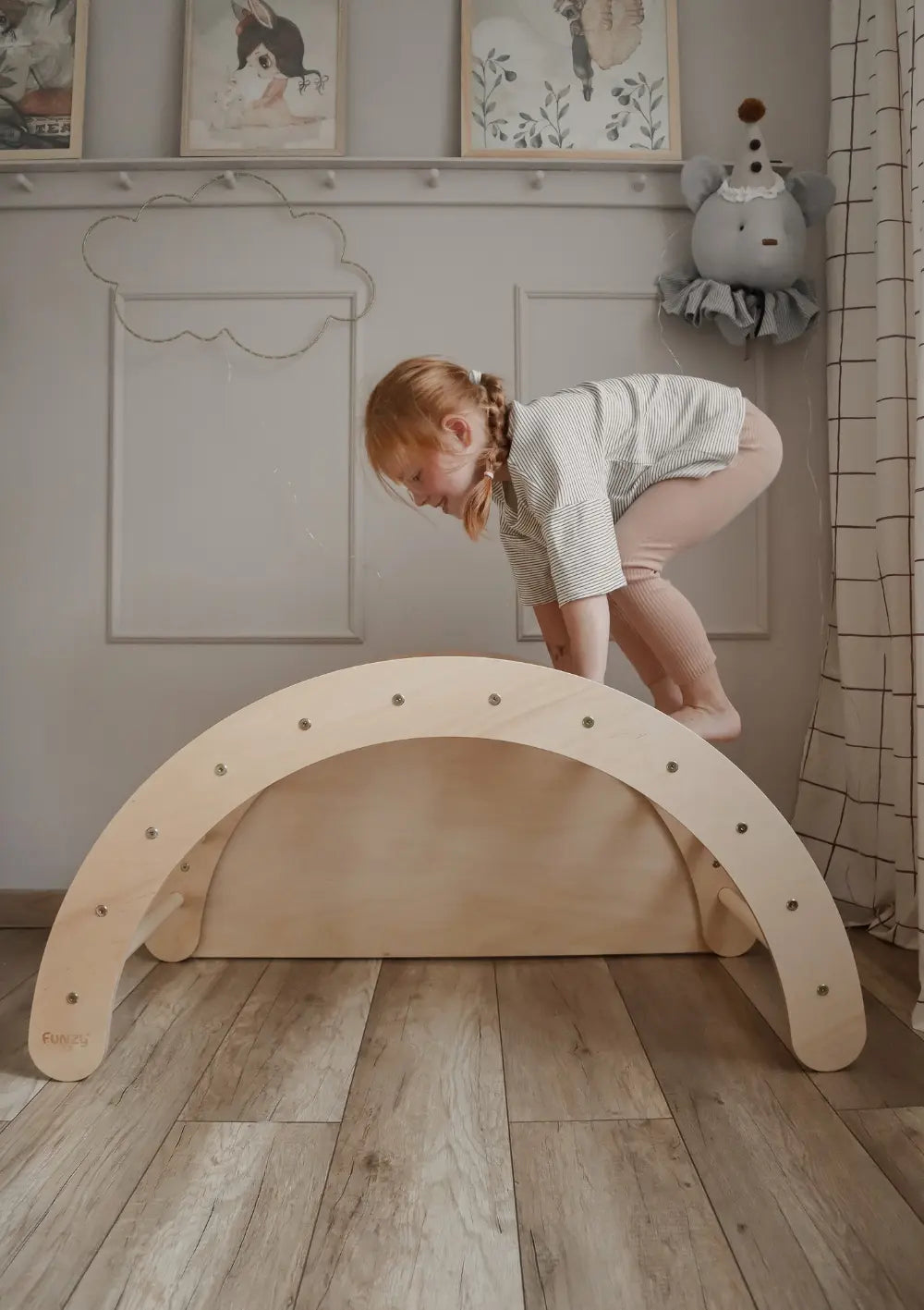 Mädchen klettert auf dem Funzy Kletterbogen Birke Natur
