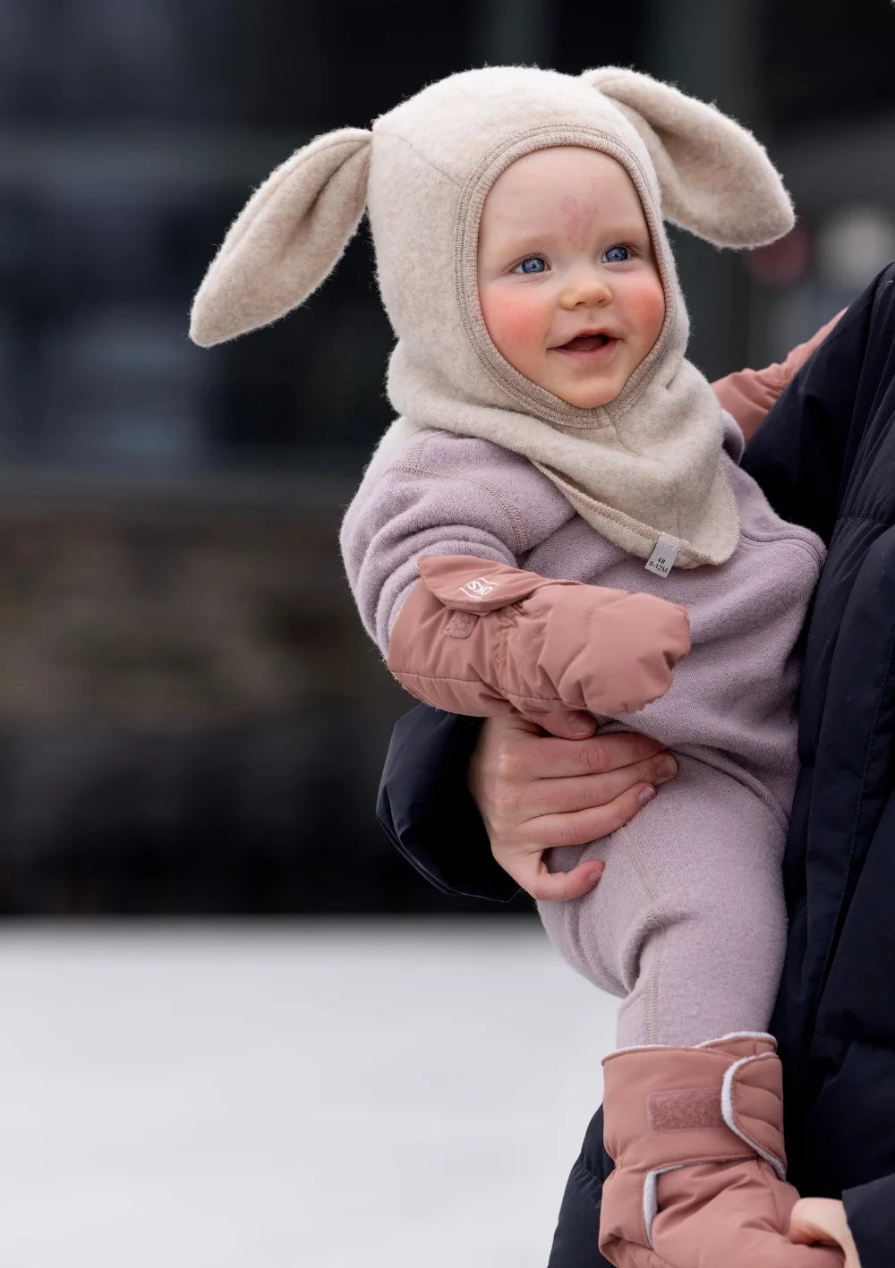 Baby mit Hasenmütze trägt die rosafarbenen Voksi Baby Fäustlinge und Booties Blush Pink
