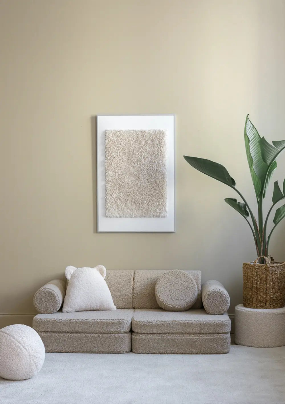 Das beigefarbene modulare Wigiwama Kindersofa Teddy Biscuit aus kuschligem Plüsch steht dekorativ arrangiert an einer Wand im Zimmer.
